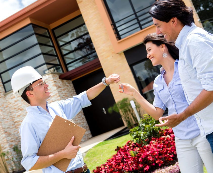 architect handling keys to a couple - all kind door services